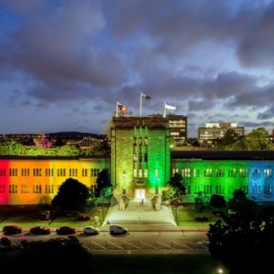 UQ's Forgan Smith Building lit up in rainbow colours. 